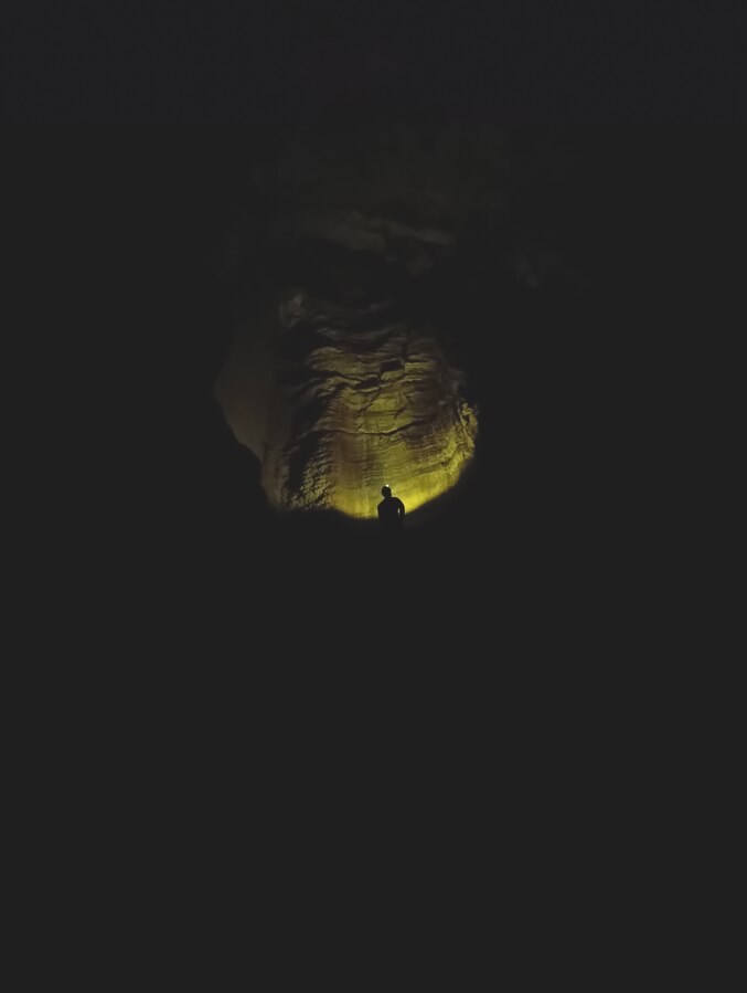 Speleologo controluce all'ingresso della Grotta dei Vitelli